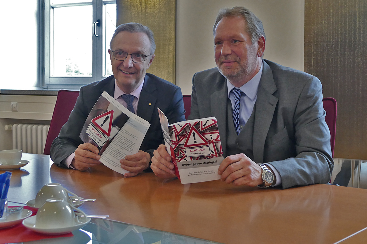 Polizeipräsident Frank Richter und Sparkassenvorstand Volker Behr stellen eine Broschüre vor